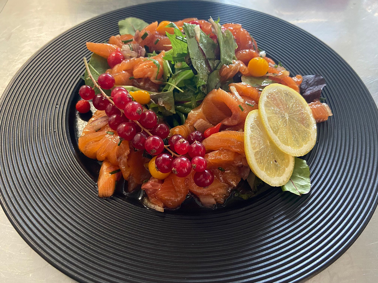 Tataki d'espadon frais, groseilles et citron, dressé sur assiette noire